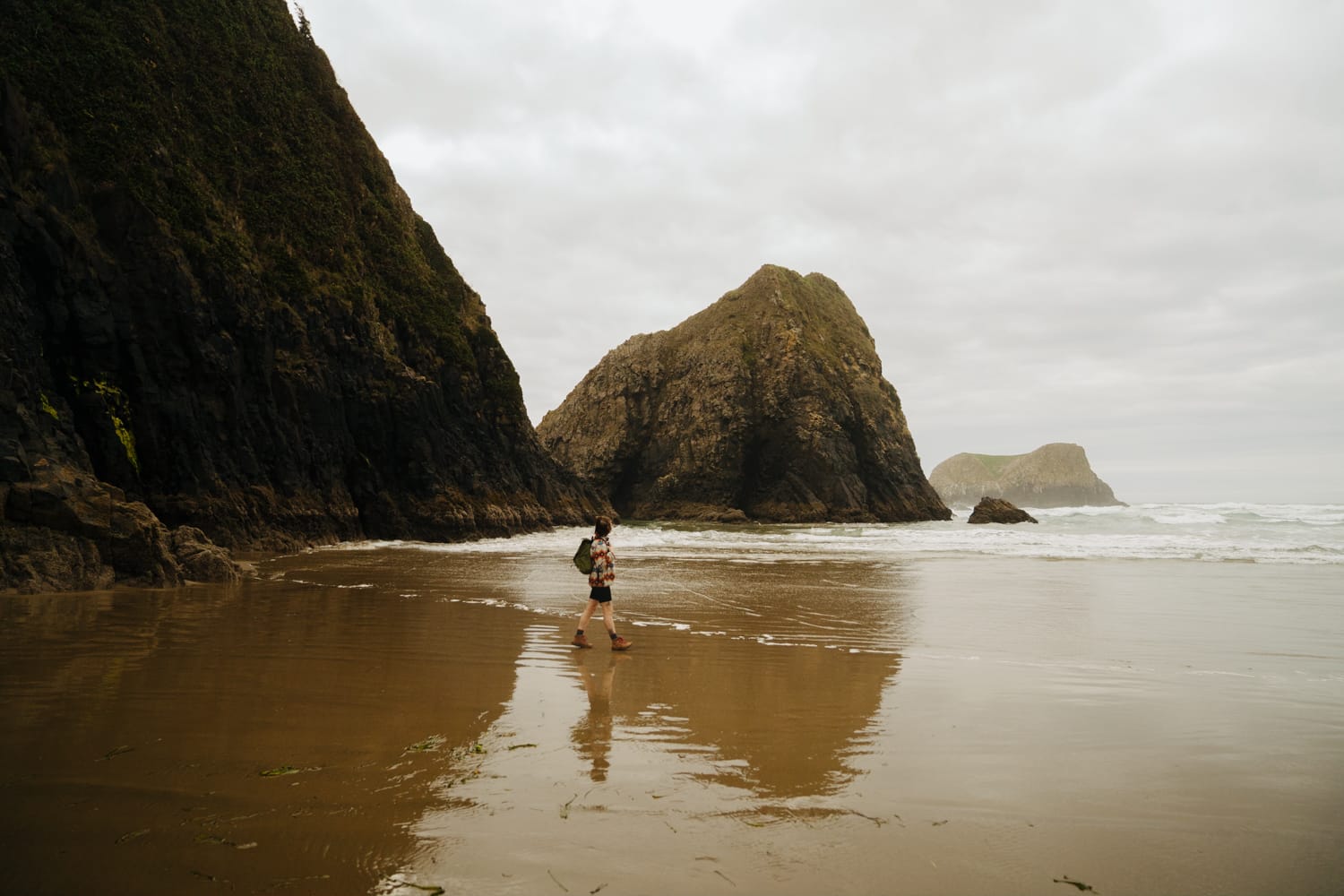 A girl is walking on the san at Crescent Beach in Ecola State Park, Oregon.