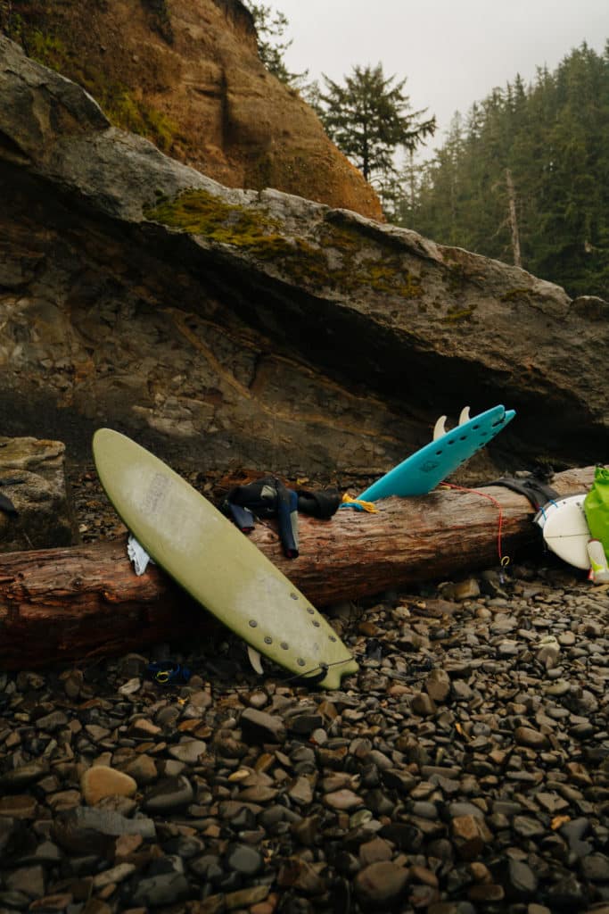 A surfboard is leaning on driftwood at Short Sands Beach.