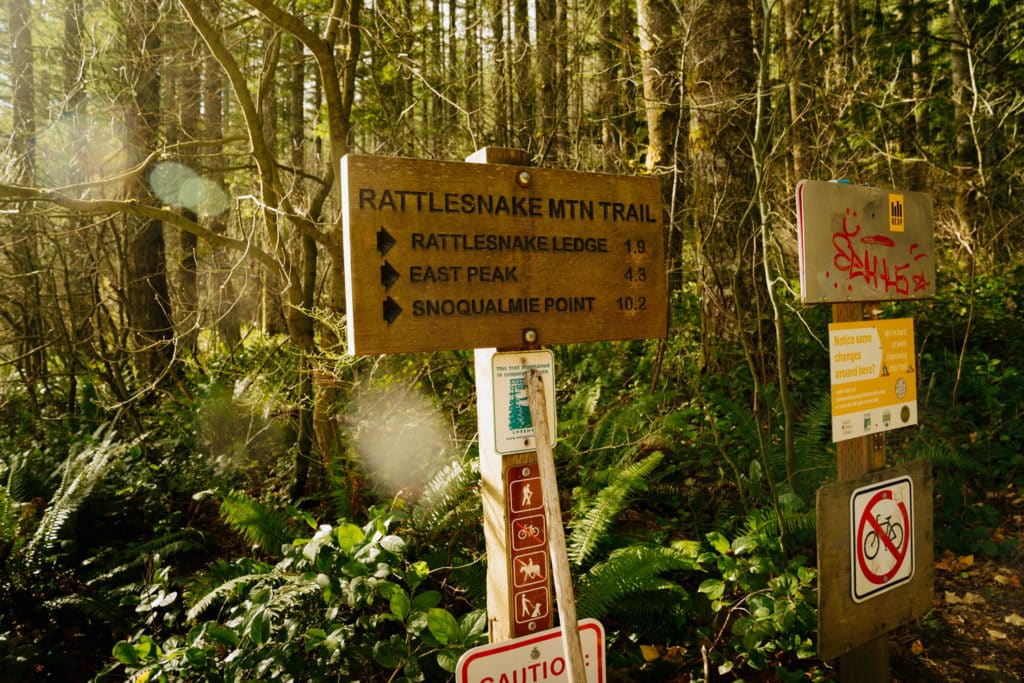 A wooden sign with "Rattlenake Ledge Trail" written on it, with an arrow pointing to the right.
