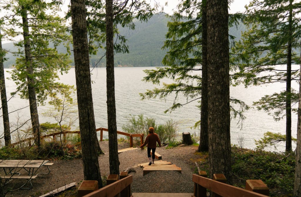 Me walking down some wooden stairs at an overlook of Lake Cushman.