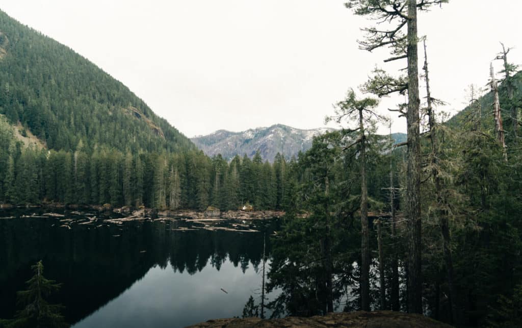 A view of Lena Lake, with mountains in the background and trees along the shore.