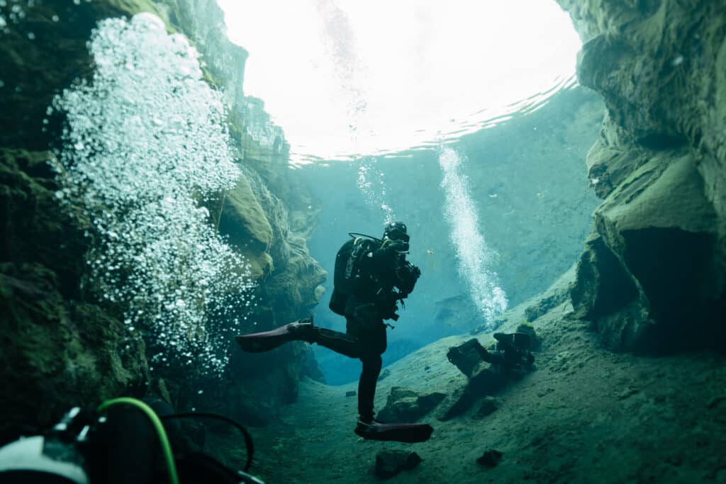 A scuba diver underwater in Iceland during a 14 day Iceland road trip itinerary.