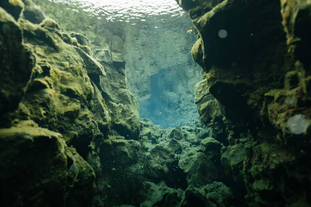 A scuba diver swimming in the Silfra Fissure in Iceland.