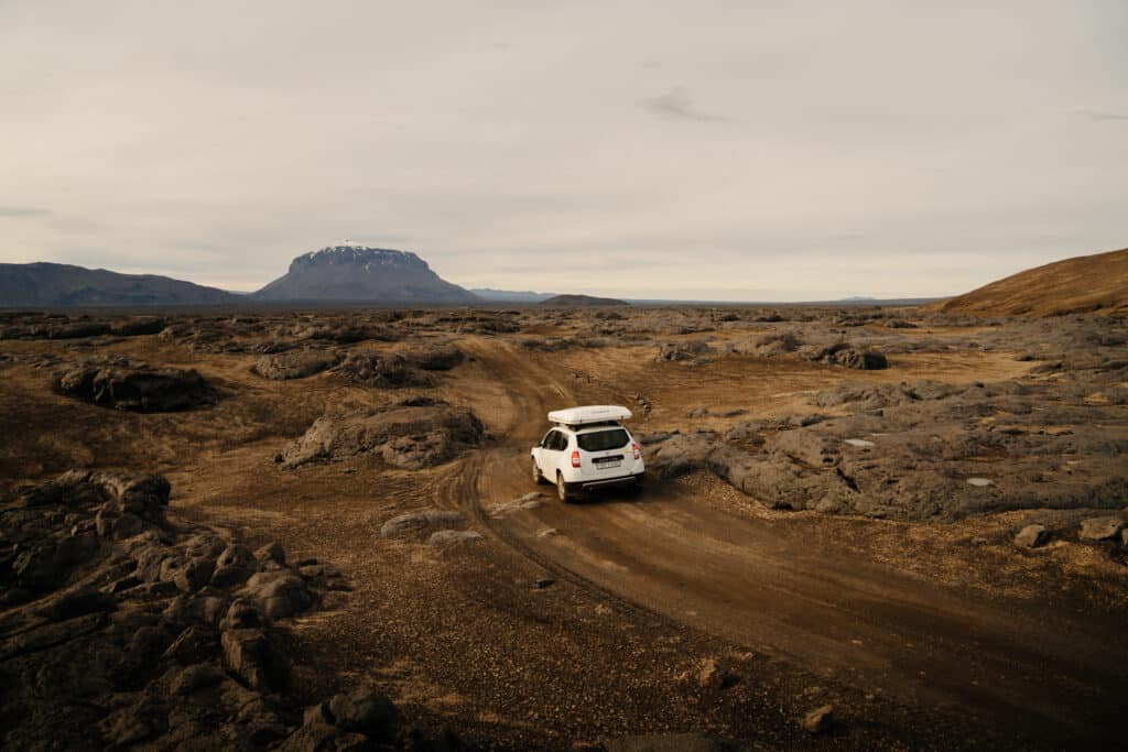 A Dacia Duster driving to Askja through a volcanic field.