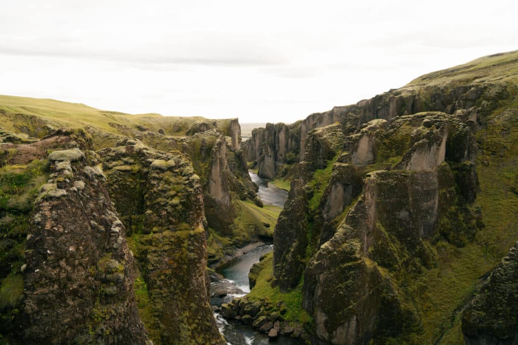 Fjaðrárgljúfur Canyon, with a mossy gorge and a river in between.