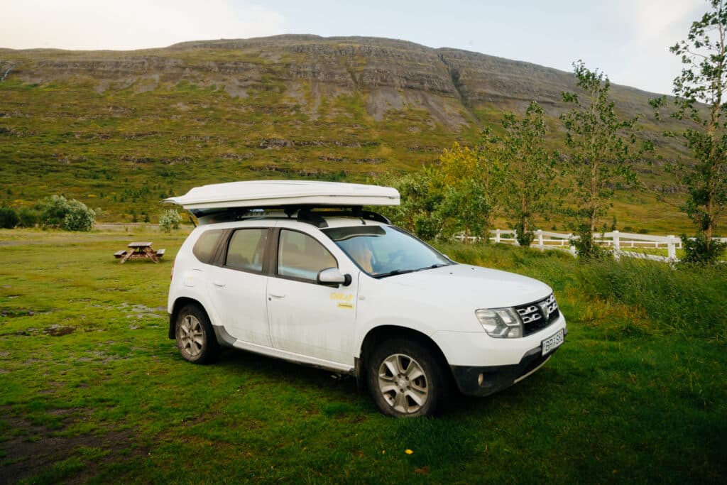 A Dacia Duster car parked in the camping area of the Hotel Heydalur.