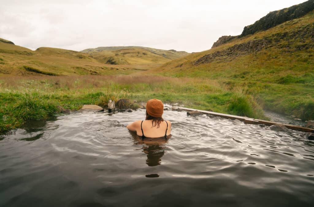 Me sitting in the hot spring at Hrunalaug, which is one of the best places to stop on the Ring Road in Iceland.