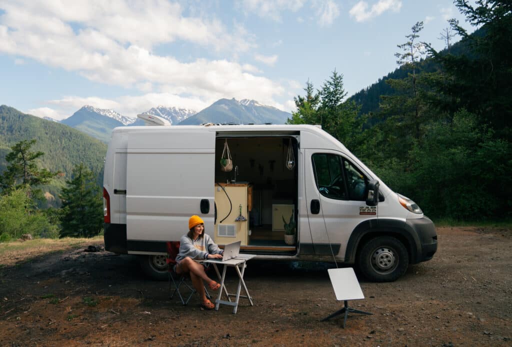 A photo of me sitting outside my van using the Starlink for wifi on the road.