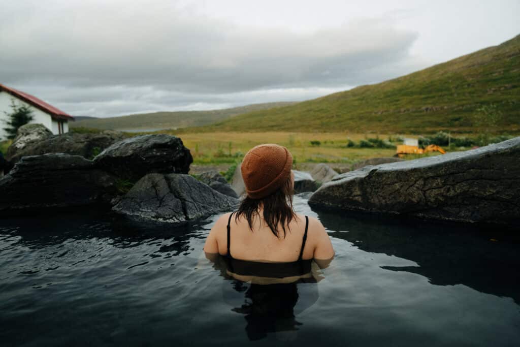 Me sitting in a hot spring at the Hotel Heydalur, which is one of the best things to do in the Westfjords, Iceland.