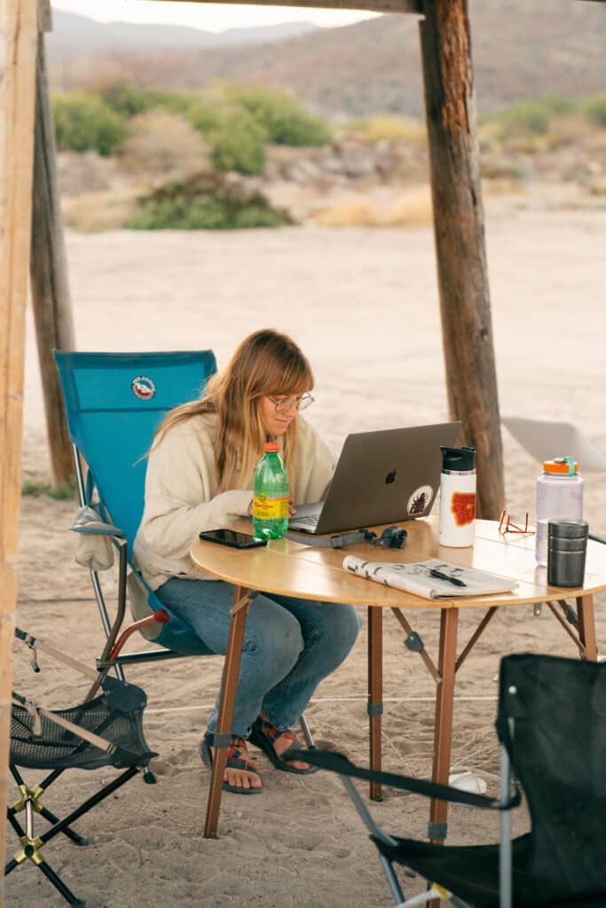 My friend Molly working remotely on a beach in Baja, using a Starlink to get internet for van life.